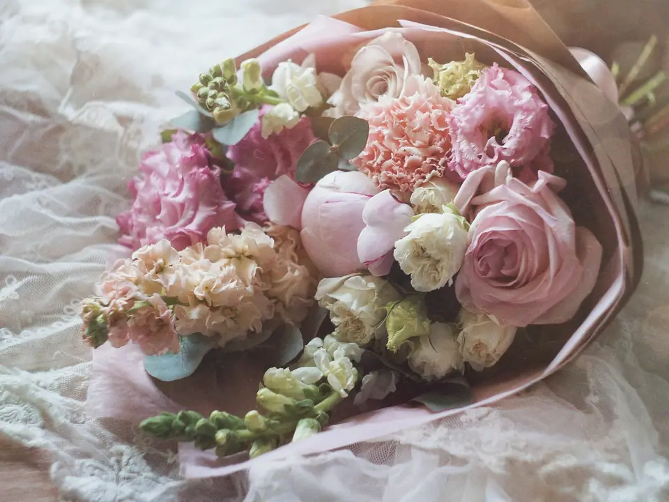 Ramo de flores rosas sobre encaje